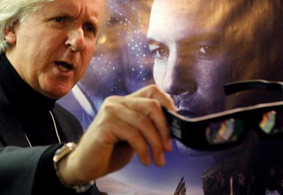 Diretor canadense James Cameron mostra óculos 3D na frente de cartaz de Avatar