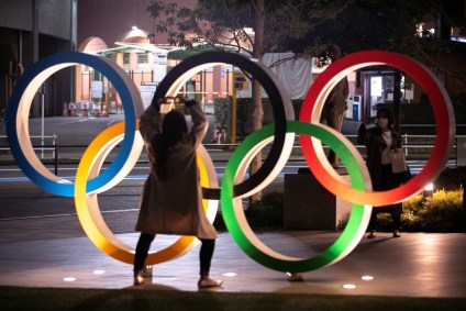 Mulheres ao lado do símbolo olímpico em Tóquio