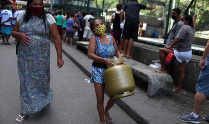 mulher carrega botijão de gás 