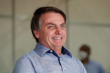 O presidente Jair Bolsonaro sorri