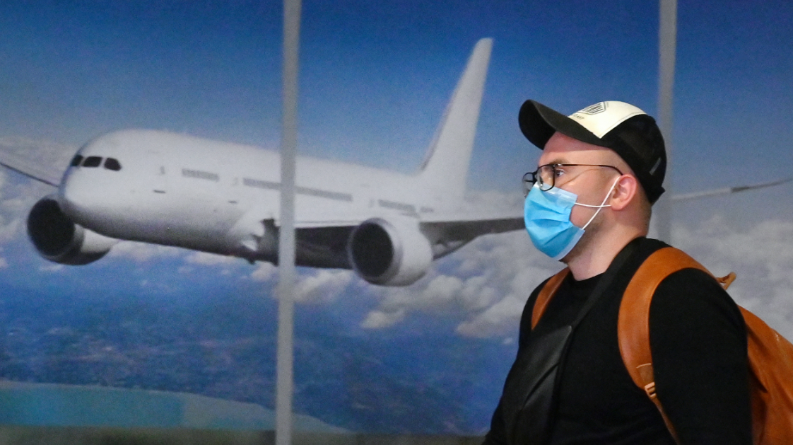 Viajante usa máscara em aeroporto depois de chegar da China
