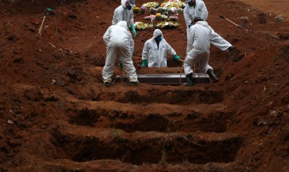 Coveiros em roupas de proteção enterram vítima da Covid-19 no cemitério São Luiz