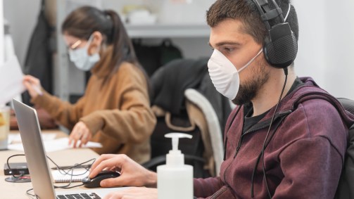 Pessoas trabalhando usando máscaras respiratórias.