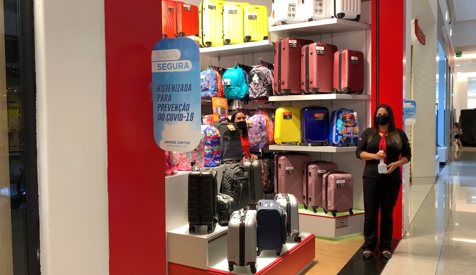 Funcionária com frasco de álcool em gel na porta de loja no shopping MorumbiTown