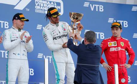 Lewis Hamilton (ao centro) recebe o troféu de vencedor, Fórmula 1