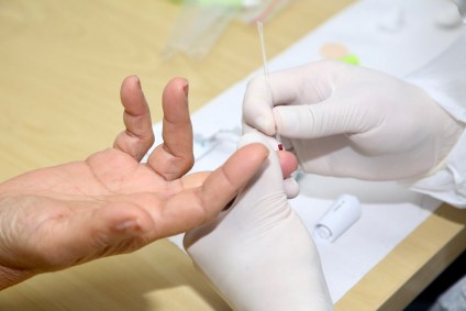 Profissional conduz teste rápido para detecção da Covid-19