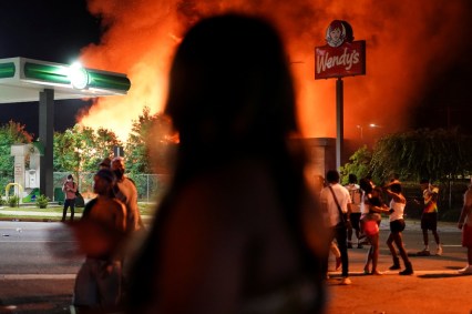 Após protestos, pessoas observam incêndio em loja da rede de lanchonetes Wendy's