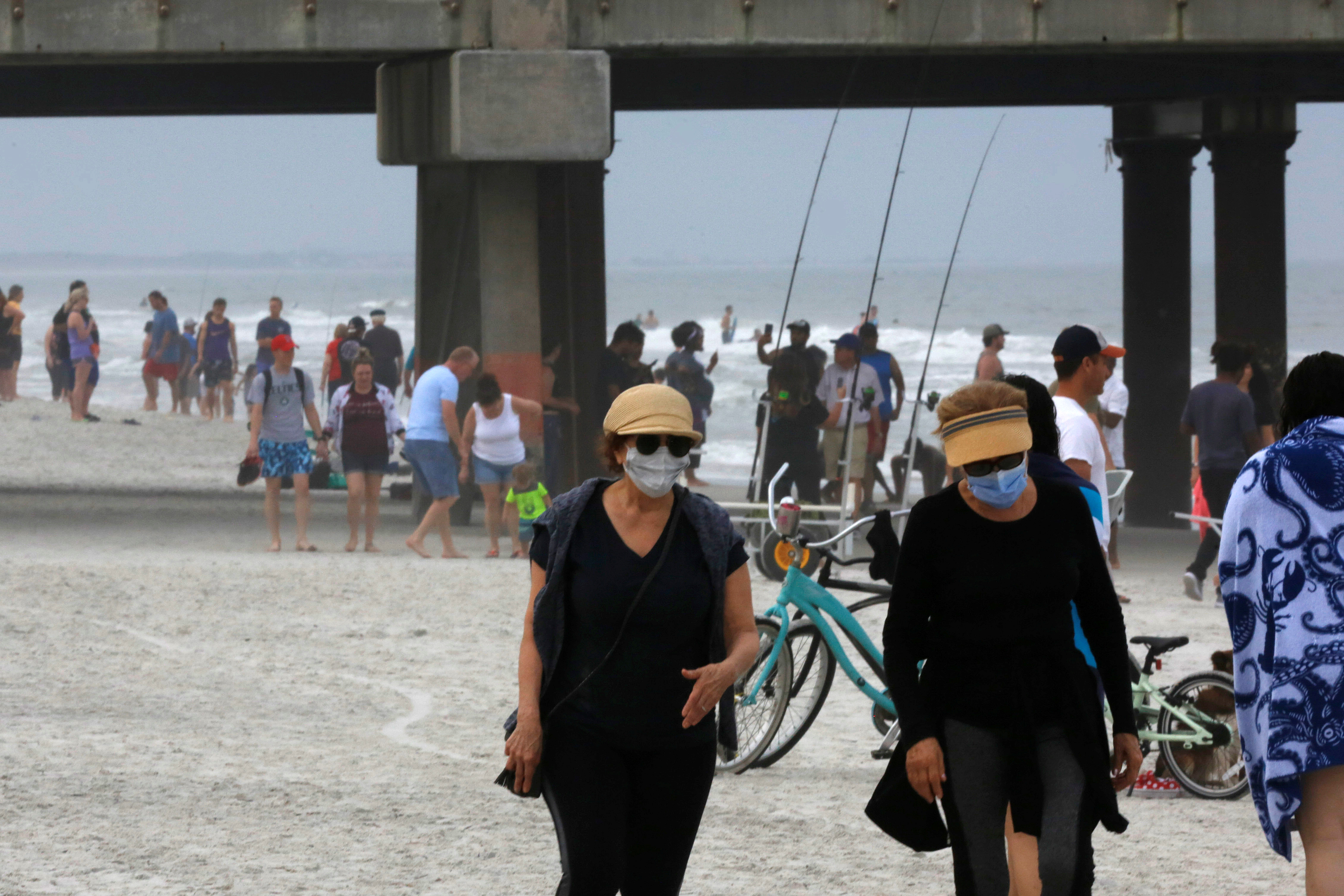 Pessoas caminham em praia na cidade de Jacksonville, na Flórida
