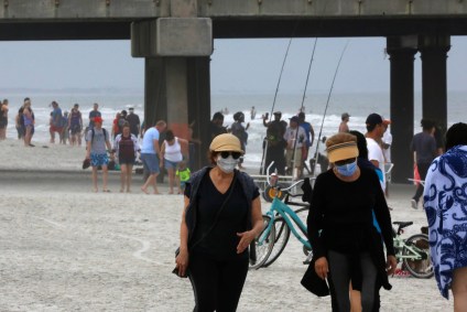 Pessoas caminham em praia na cidade de Jacksonville, na Flórida