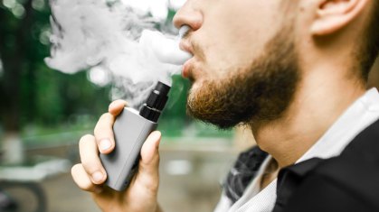 Homem fuma cigarro eletrônico.