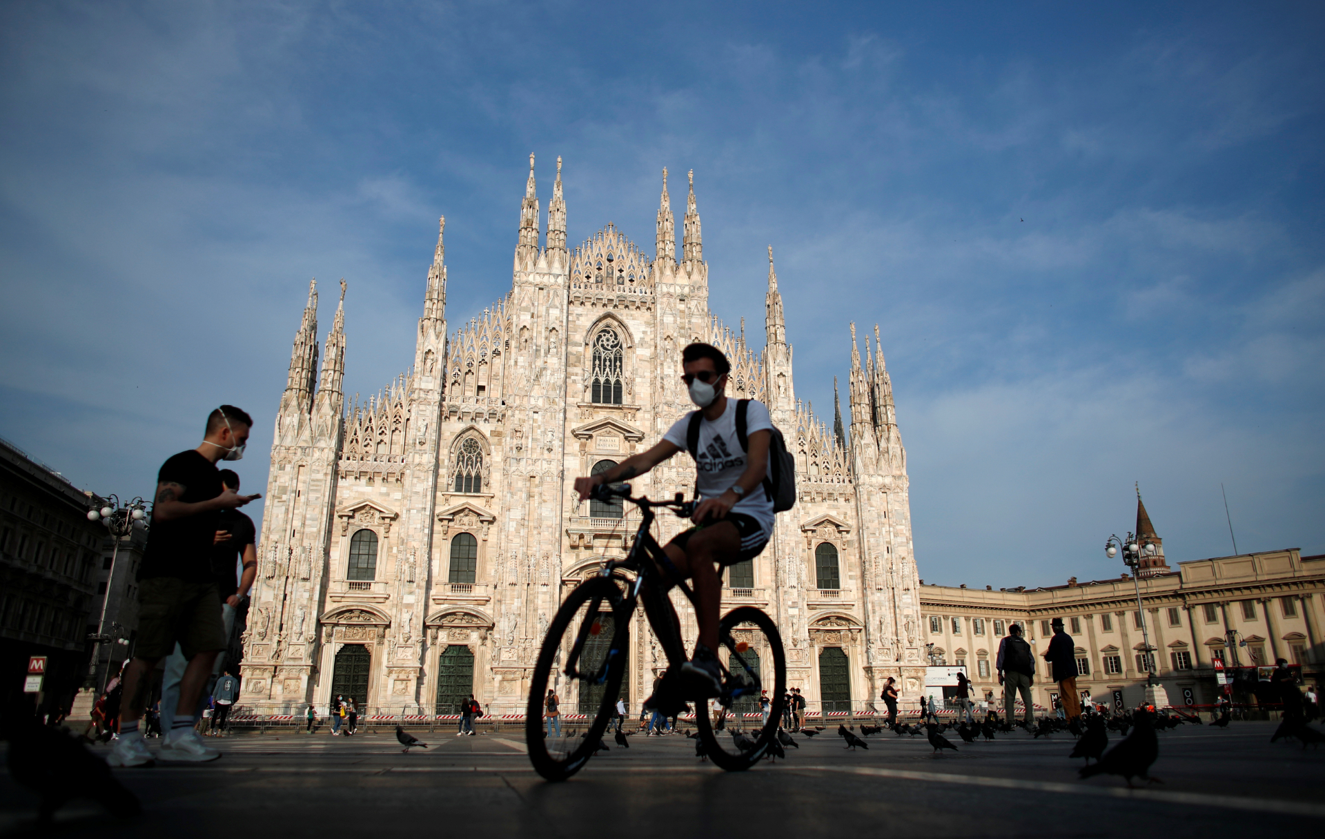 Ciclista passa pela Praça Duomo, em Milão