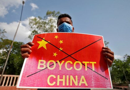 Manifestante na Índia segura cartaz defendendo boicotes contra a China