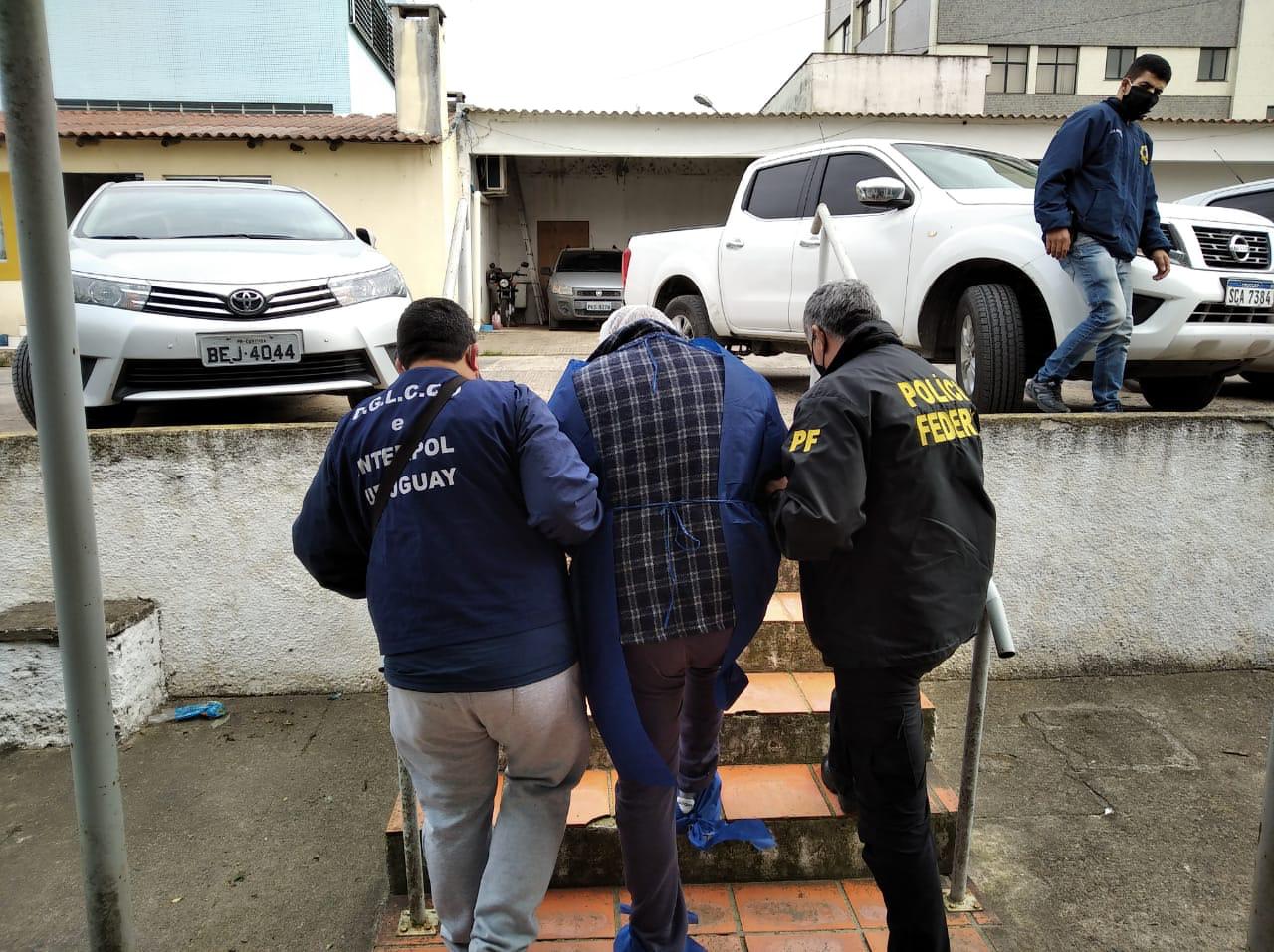 Agentes da Polícia Federal e Interpol levam uruguaio suspeito de roubo