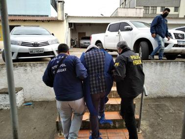 Agentes da Polícia Federal e Interpol levam uruguaio suspeito de roubo