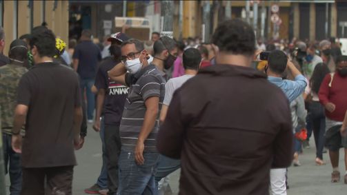 Pessoas usam máscaras ao caminhar nas ruas em São Paulo