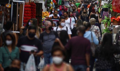 Pessoas circulam de máscara por rua de comércio popular no centro do RJ
