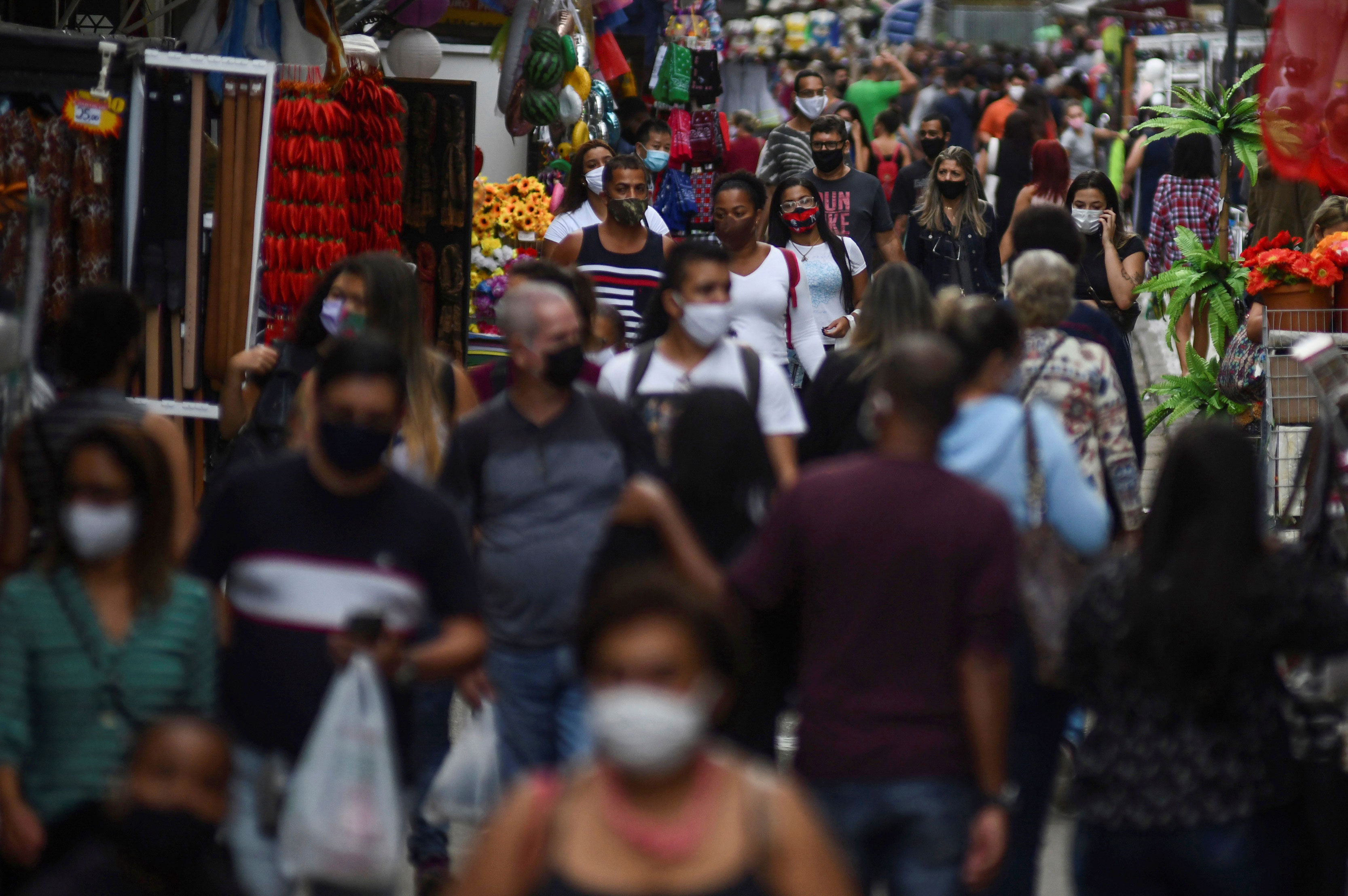 Pessoas circulam de máscara por rua de comércio popular no centro do RJ