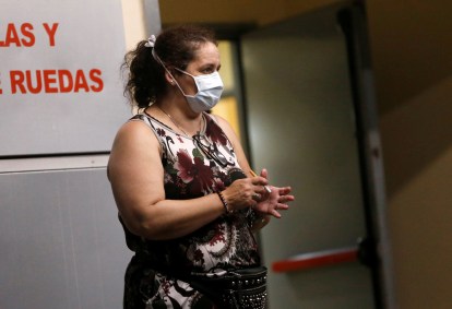 Mulher com máscara em hospital após morte por coronavírus na Argentina