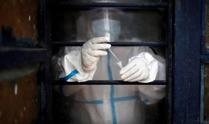 Agente de saúde analisa amostra de teste para coronavírus em Nova Délhi