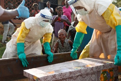 Mãe de criança suspeita de ter morrido de ebola chora ao lado do caixão