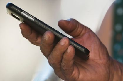 Homem manuseia celular