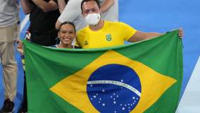 No fim, ela pegou a bandeira do Brasil para uma foto com Francisco Porath Neto, seu técnico na seleção