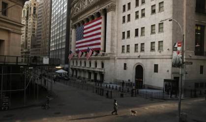Homem caminha pela Wall Street, em Nova York