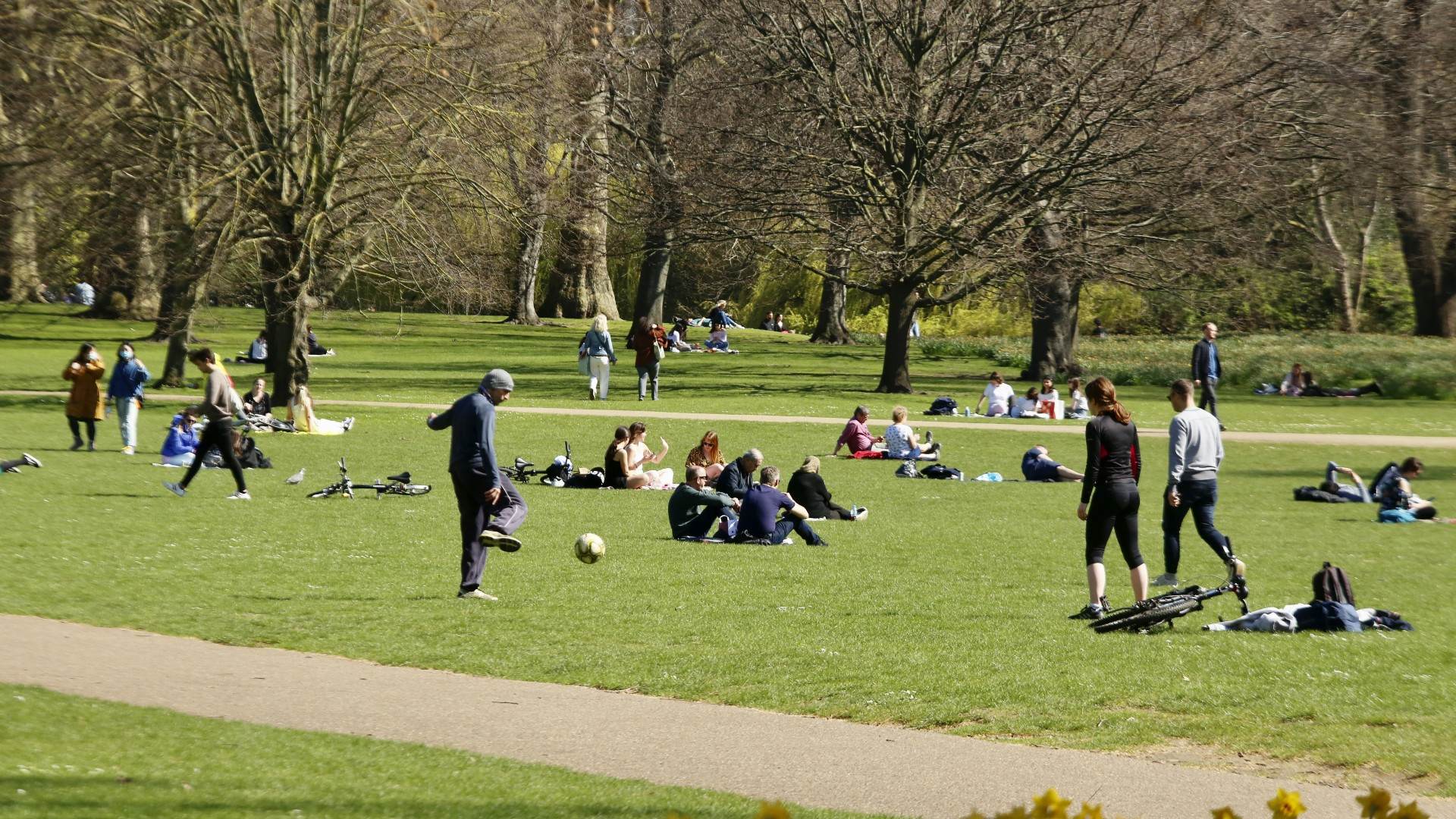 Pessoas curtem um dia de sol em um parque de Londres Pessoas curtem um dia de sol em um parque de Londres