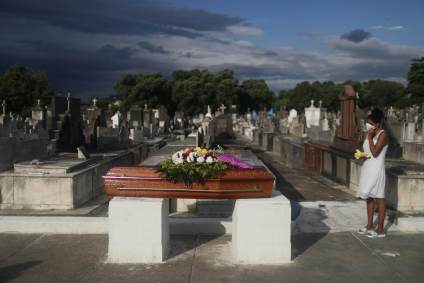 Mulher acompanha enterro da mãe, que morreu de Covid-19, em cemitério do Rio
