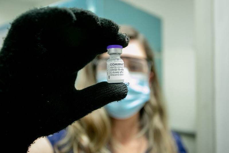 Profissional da saúde com doses da vacina Pfizer Profissional da saúde com doses da vacina Pfizer