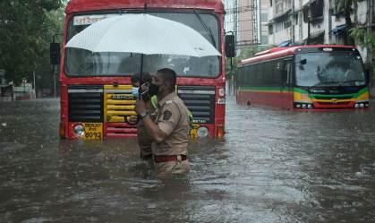 Policiais em ruas alagadas de Mumbai