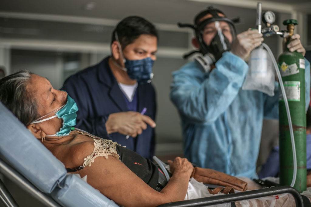 Um médico observa enquanto uma enfermeira verifica o fluxo de oxigênio de uma mu Um médico observa enquanto uma enfermeira verifica o fluxo de oxigênio de uma mu