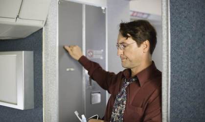 Passageiro na fila para usar banheiro de um avião