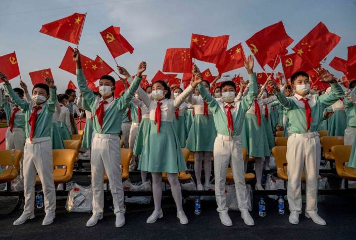 Estudantes chineses cantam com bandeiras nacionais na cerimônia que marcou o 100º aniversário do Partido Comunista, em Pequim, China / Getty Images