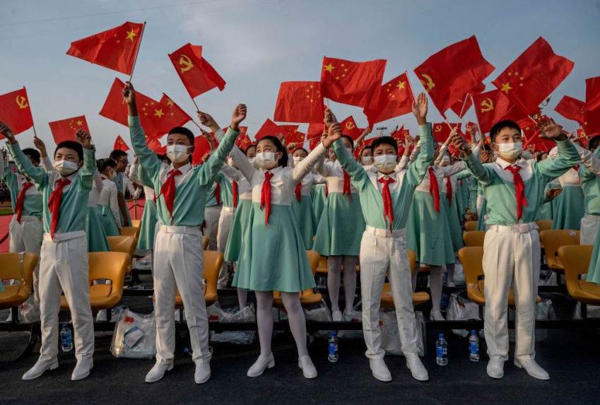 Estudantes chineses cantam com bandeiras nacionais na cerimônia que marcou o 100º aniversário do Partido Comunista, em Pequim, China / Getty Images