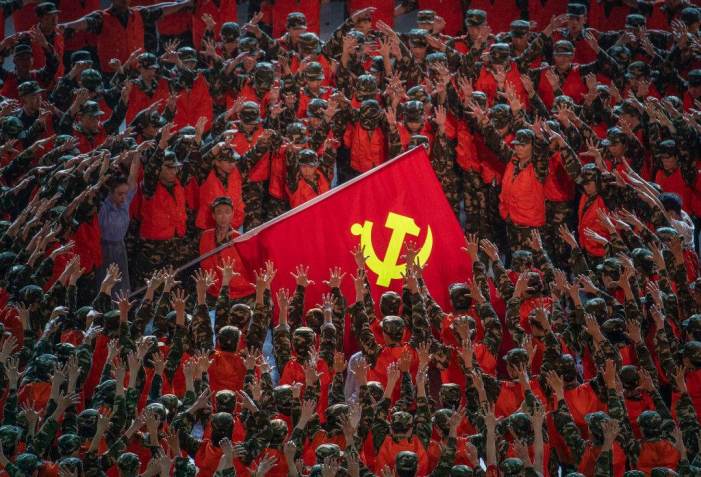 Artistas no papel de socorristas se reúnem em torno de uma bandeira do Partido Comunista durante uma apresentação de gala antes do 100º aniversário da fundação do Partido Comunista Chinês em Pequim na segunda-feira, 28 de junho de 2021 / Getty Images
