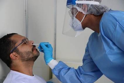 Profissional da Fiocruz realiza teste PCR da Covid-19 em morador