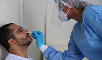 Profissional da Fiocruz realiza teste PCR da Covid-19 em morador
