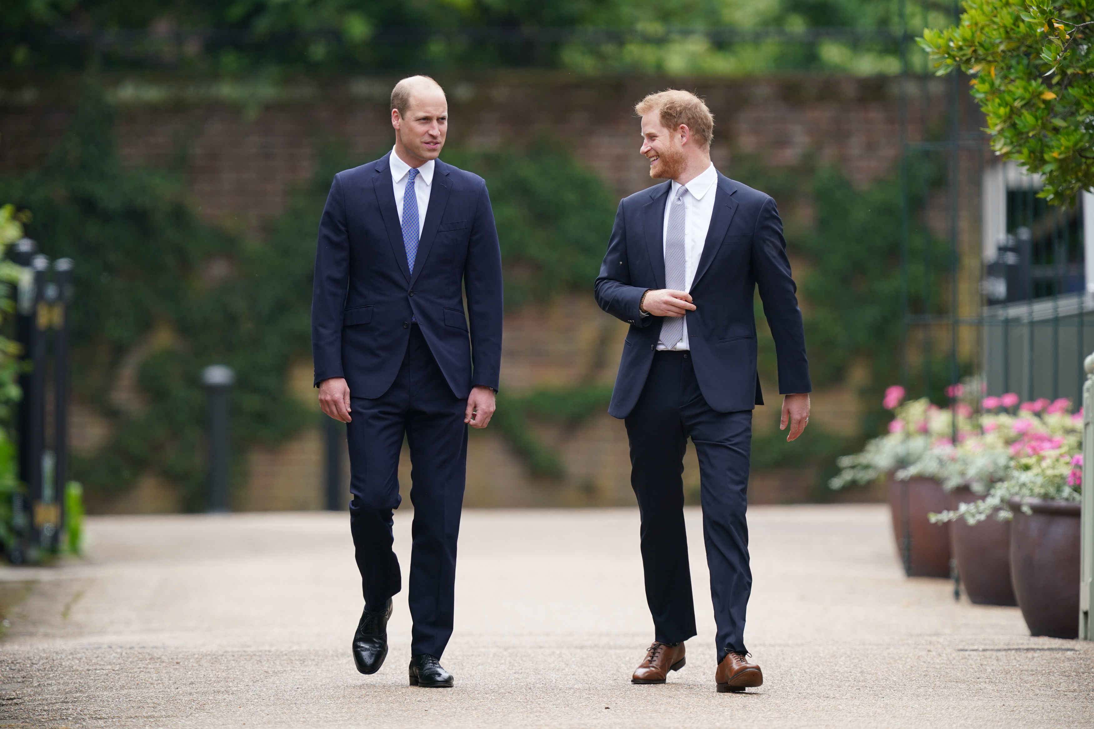 Príncipe William e príncipe Harry caminham no Palácio de Kensington