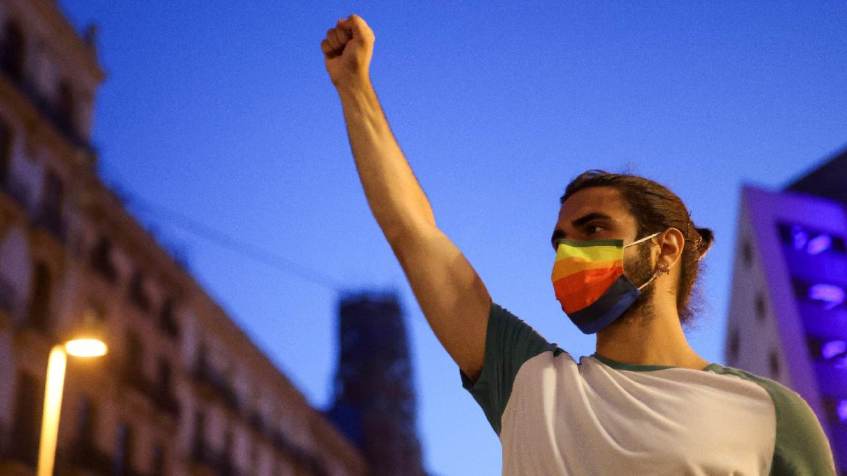 Manifestante em protesto com bandeira do arco-íris que representa comunidade LGTBQ, em Barcelona