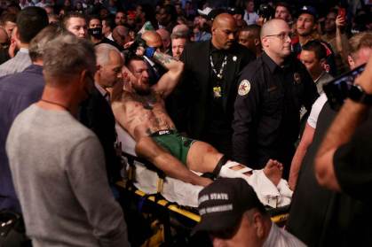 Lutador de UFC Conor McGregor sai do ginásio carregado após quebrar a perna
