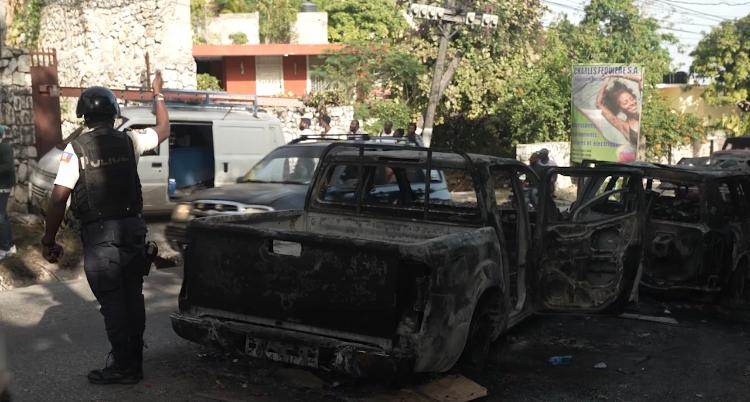 Carros incendiados de supostos mercenários no distrito de Petion-Ville, em Porto Carros incendiados de supostos mercenários no distrito de Petion-Ville, em Porto