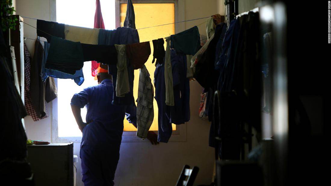 Operário nepalês olha pela janela de seu quarto em acampamento de trabalhadores Operário nepalês olha pela janela de seu quarto em acampamento de trabalhadores