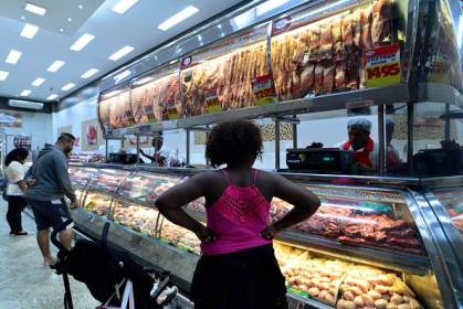 Clientes esperam na fila de supermercado para comprar carne