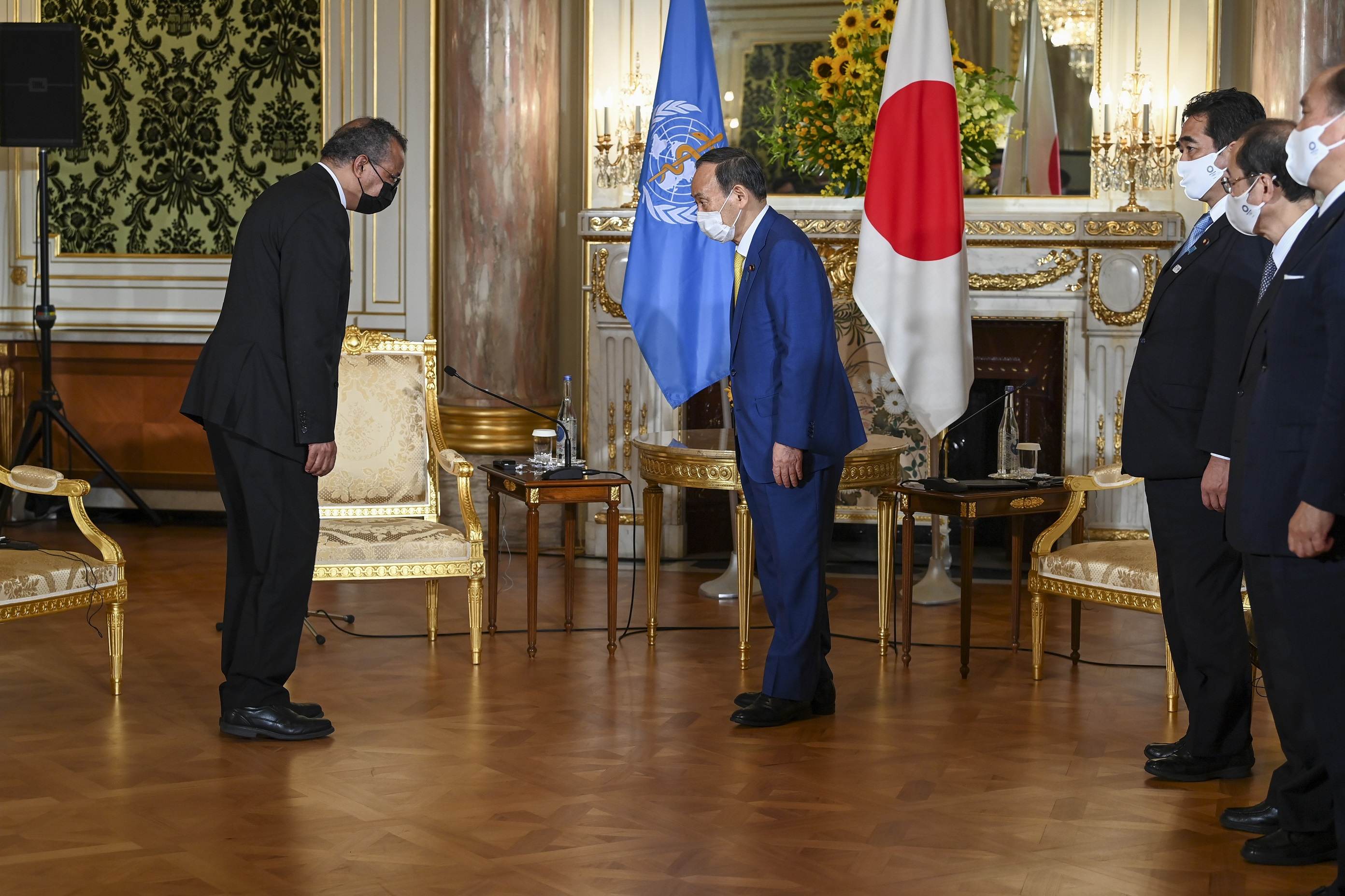 Tedros Adhanom, diretor geral da OMS, e o premiê japonês Yoshihide Suga