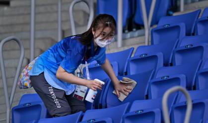Mulher higieniza as instalações de uma arena de eventos nas Olimpíadas de Tóquio