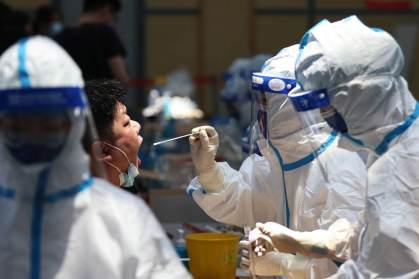 Profissionais realizando teste da Covid-19 na China