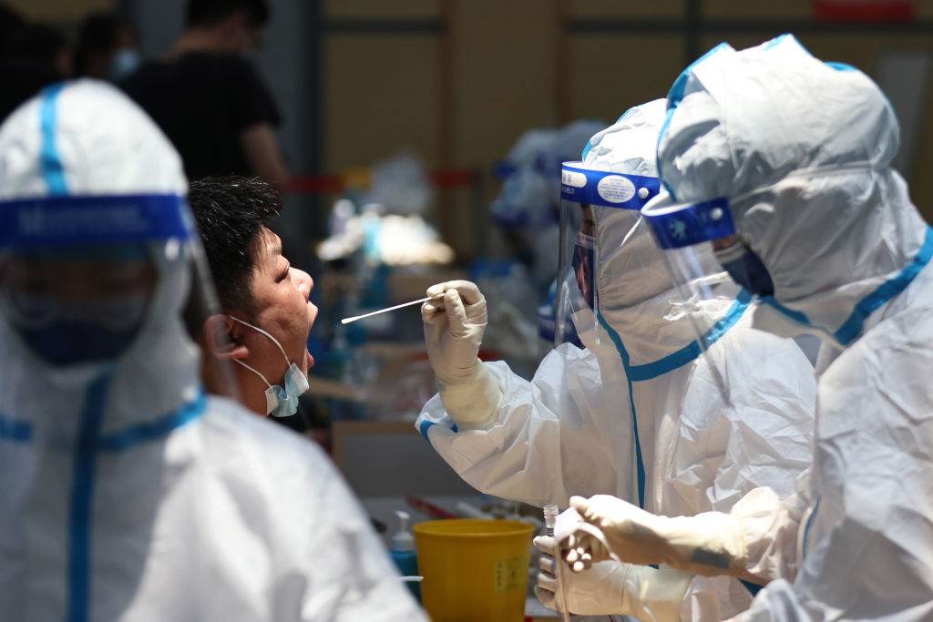 Profissionais realizando teste da Covid-19 na China / China News Service via Getty Ima