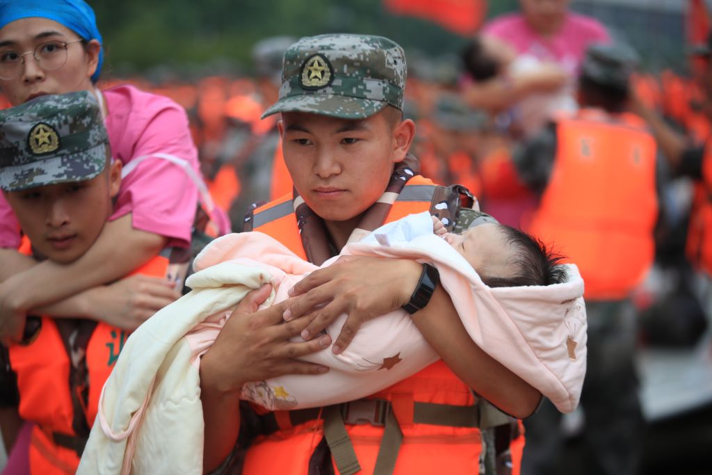 Bombeiro resgata bebê em enchentes históricas em Henan, China / Foto: Zhang Cong/VCG via Getty Images