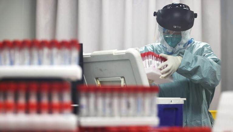 Um trabalhador médico analisa amostras de residentes locais a serem testadas para Covid-19 em um laboratório em Nanjing, China, em 24 de julho. / yangbo